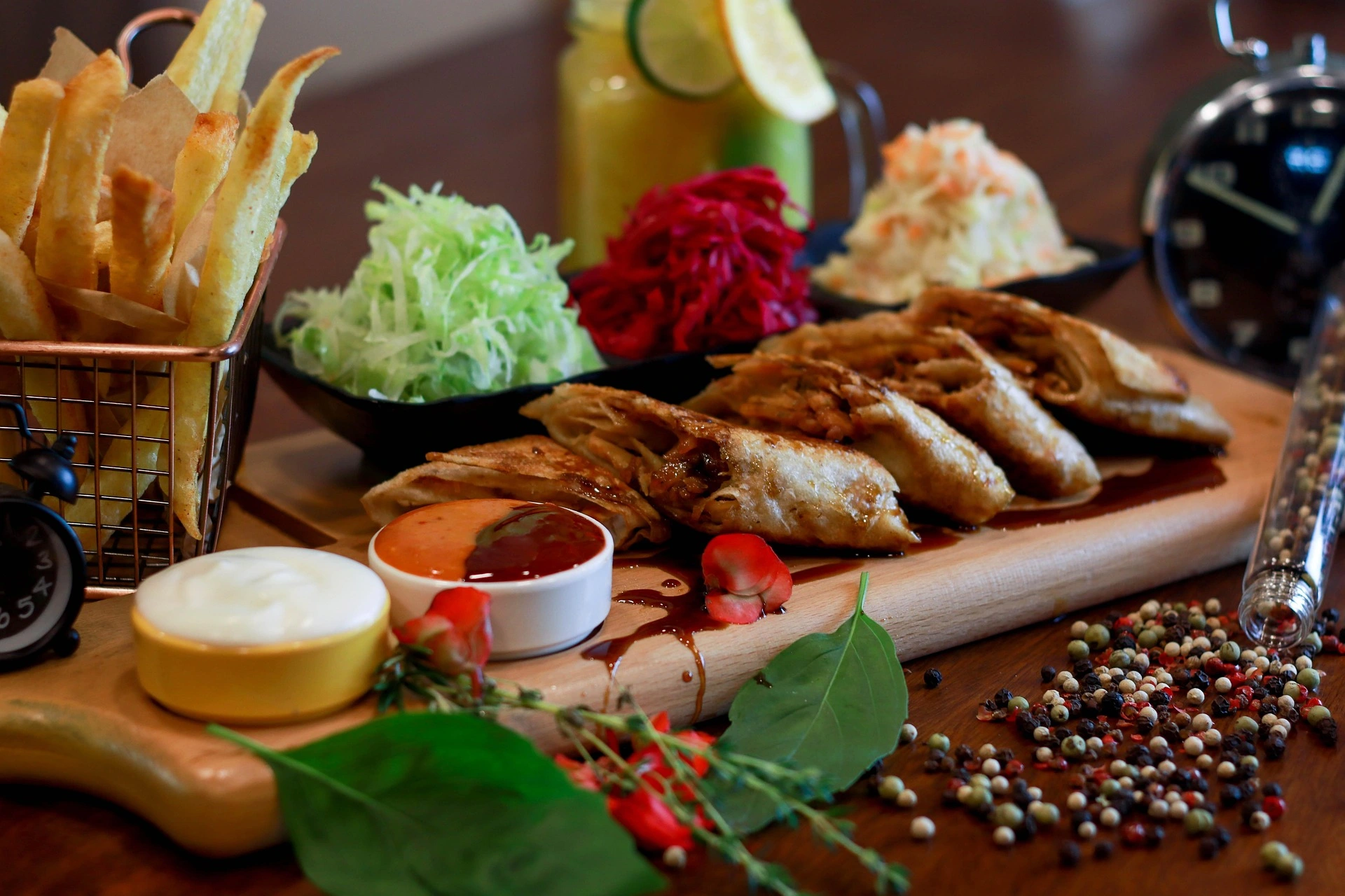 Planche de dégustation avec samoussas croustillants, frites, sauces et crudités dans un restaurant.